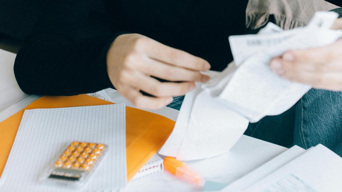 Женщина держит в руках квитанции