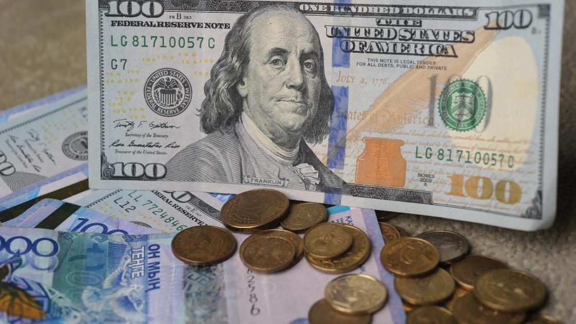 Банкноты и монеты разных валют лежат на столе