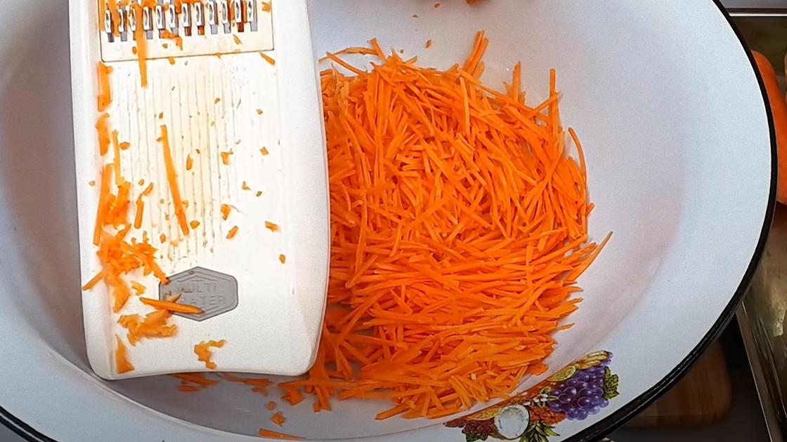 Терка и натертая морковь в большой миске