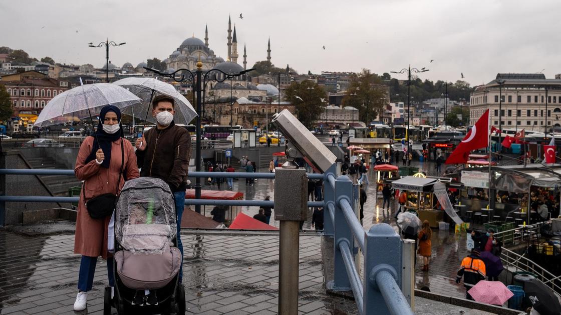 Пара в масках гуляет по Стамбулу с коляской