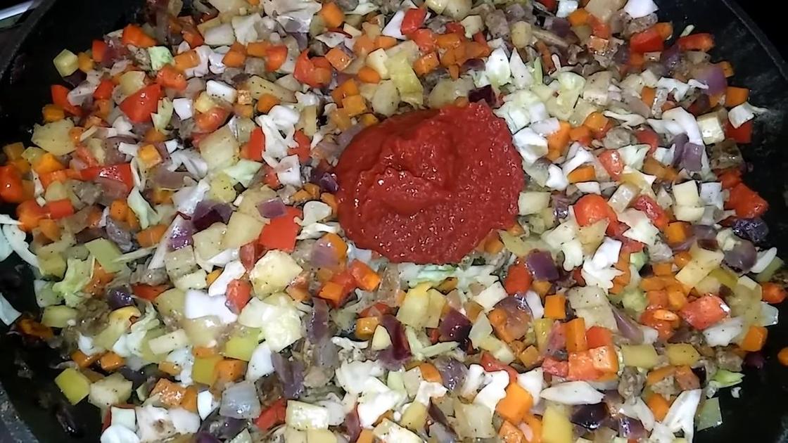 В сковороде обжаривают мясо с овощами и томатной пастой