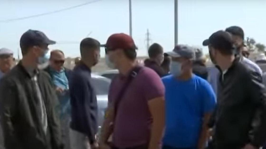 Мужчины в масках стоят на улице в Актау