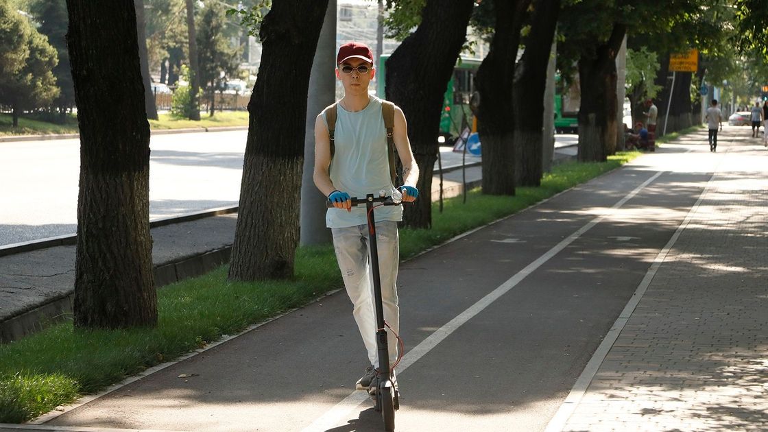 Парень на самокате едет по улице