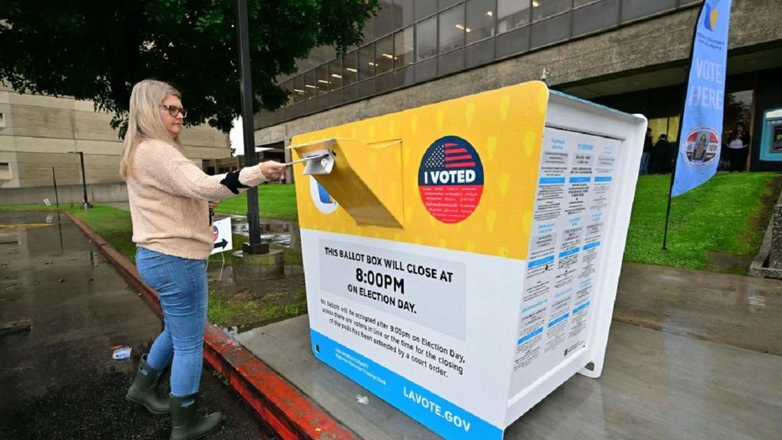 Женщина опускает бюллетень в урну для голосования