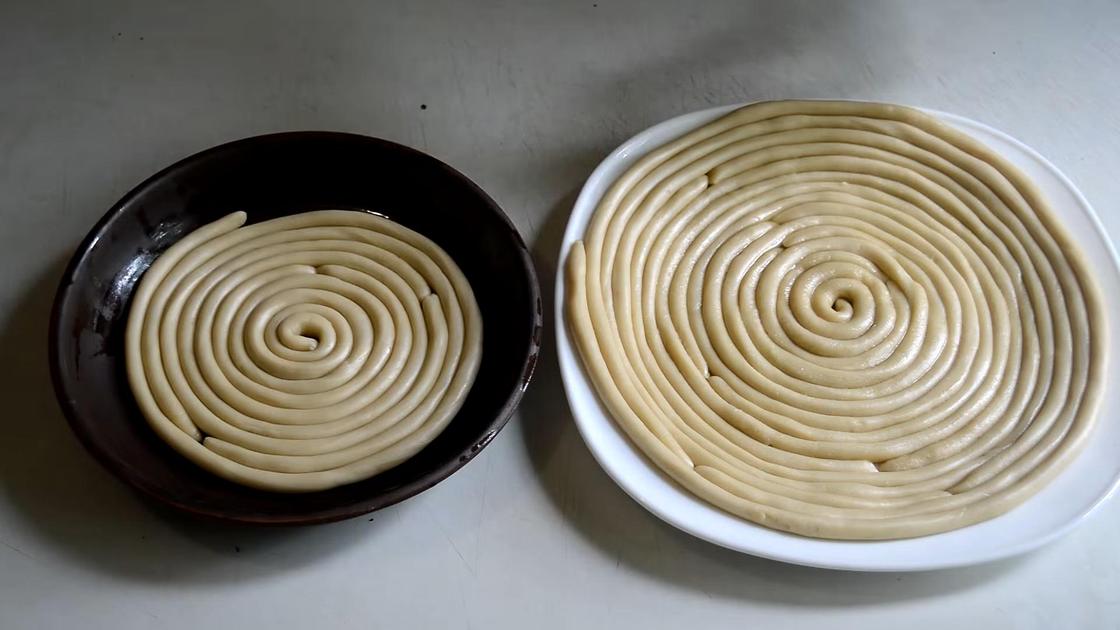 Заготовки из теста на лапшу, выложенные на тарелке спиралью