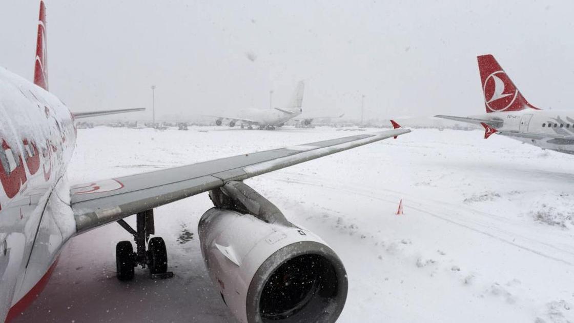 Снег падает на крыло самолета