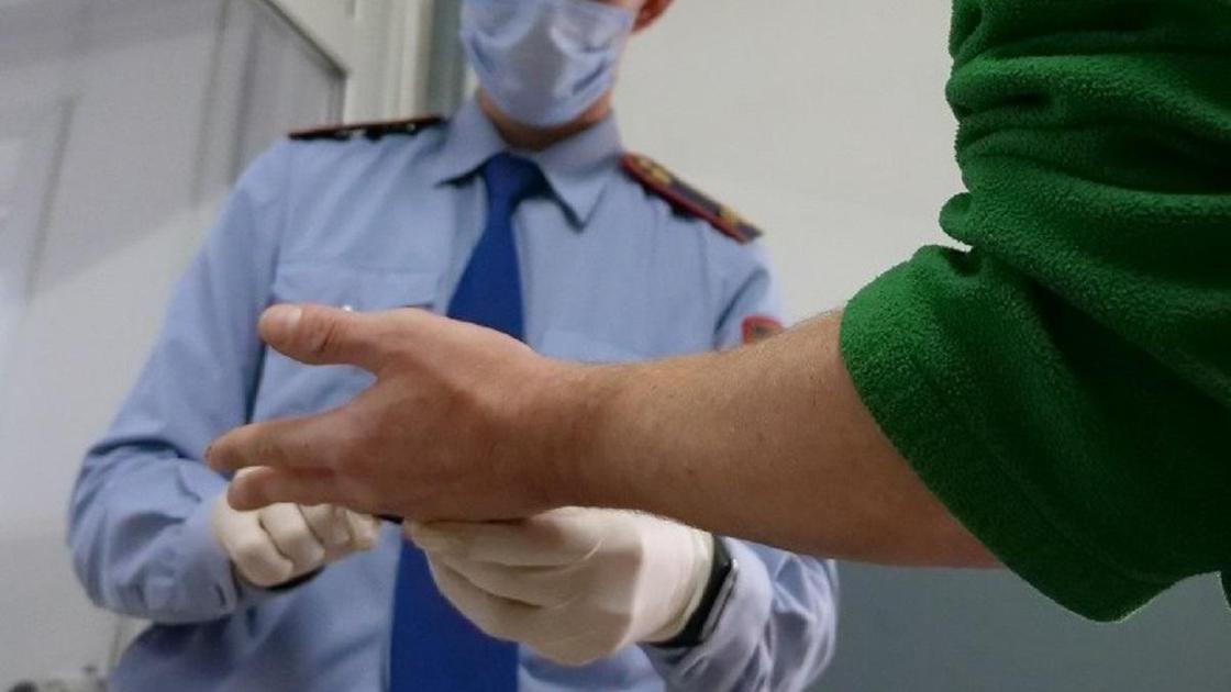 Полицейский берет отпечатки пальцев у мужчины Полицейский берет отпечатки пальцев у мужчины