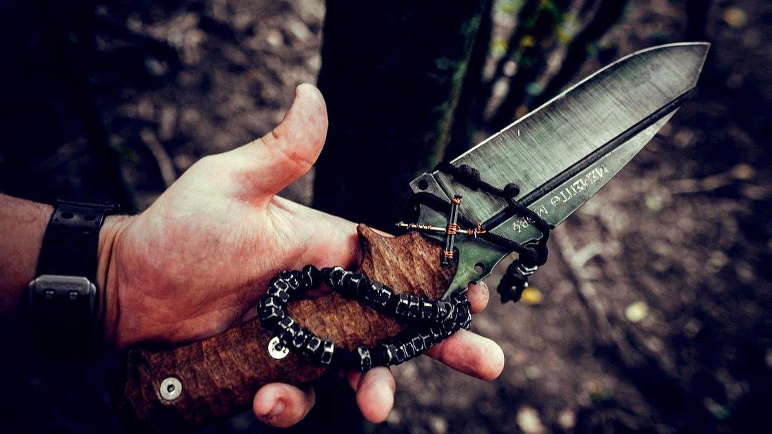 Охотничий нож в руке