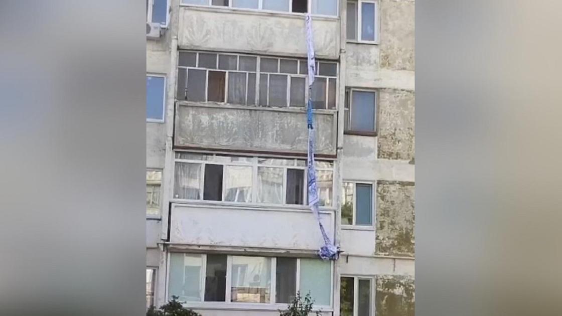 Связанные простыни и покрывала спущены с балкона в Рудном
