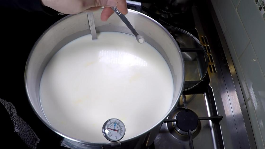 В кастрюлю с молоком мерной ложкой насыпают закваску в порошке