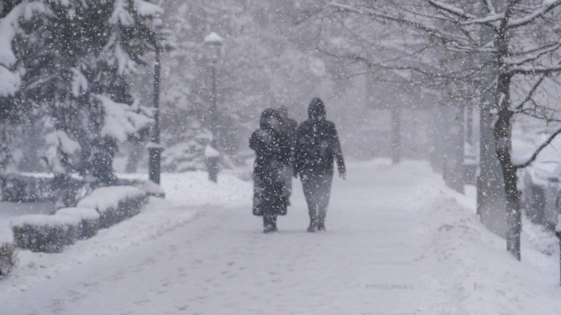 Люди идут под снегопадом в Алматы