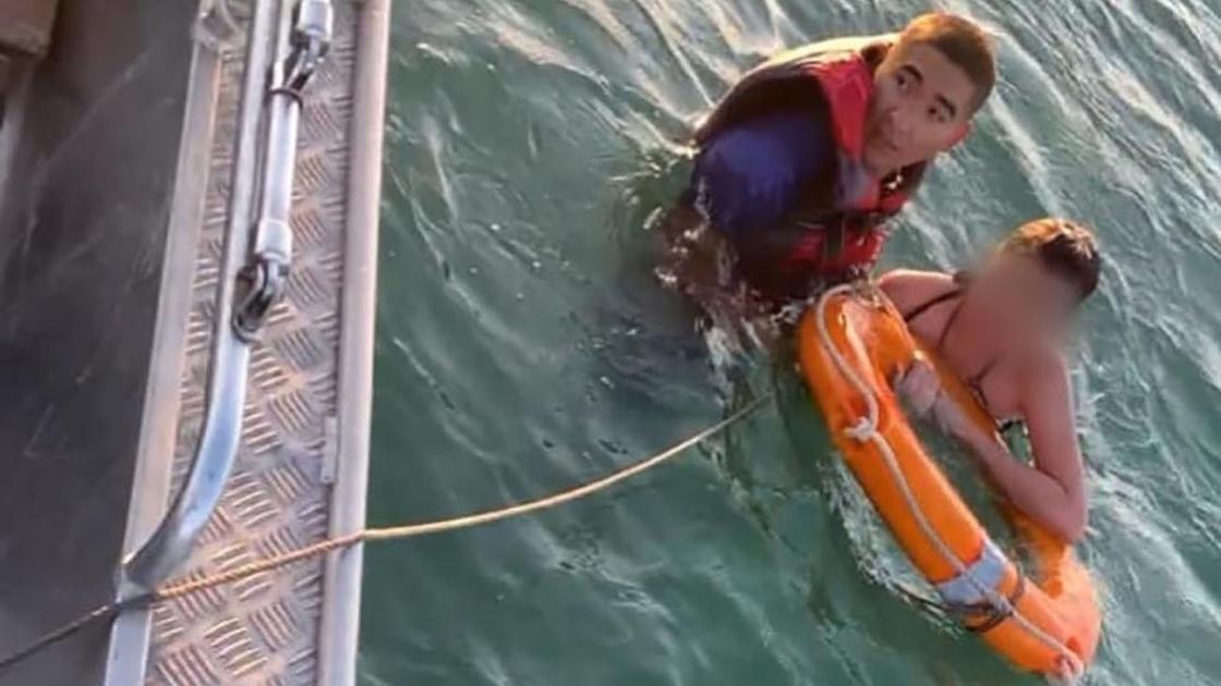 Девочка и спасатель плывут к лодке на Капшагае