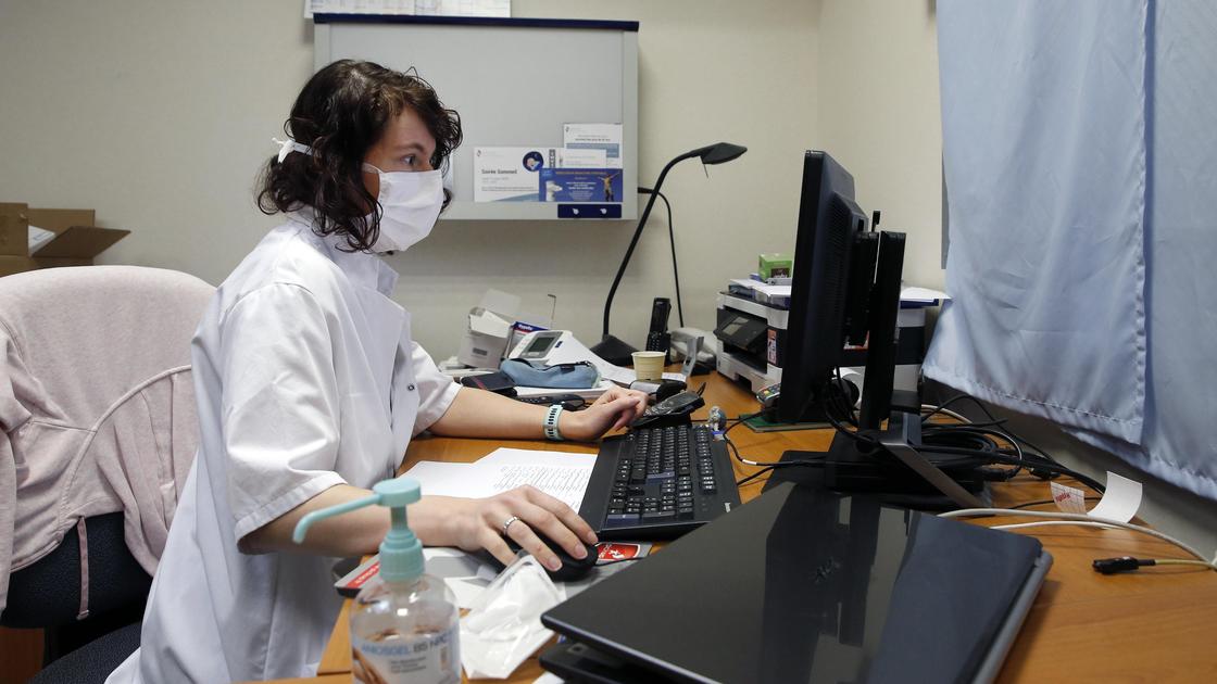 Врач сидит за компьютером в кабинете