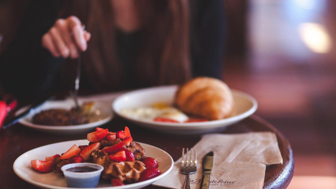 Девушка обедает за столом в кафе