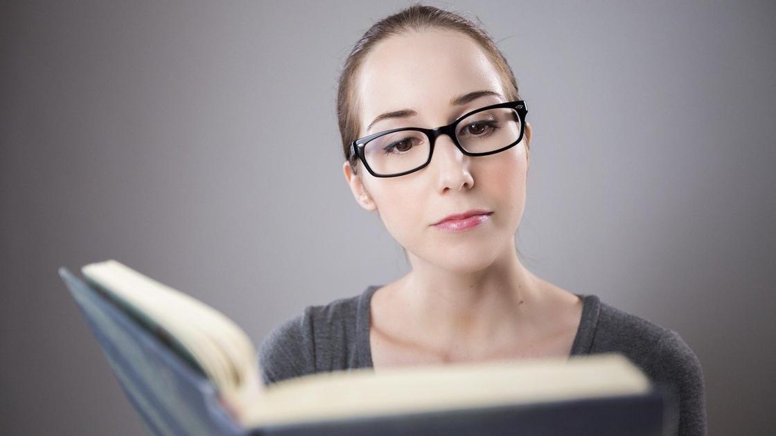 Девушка в очках читает книгу