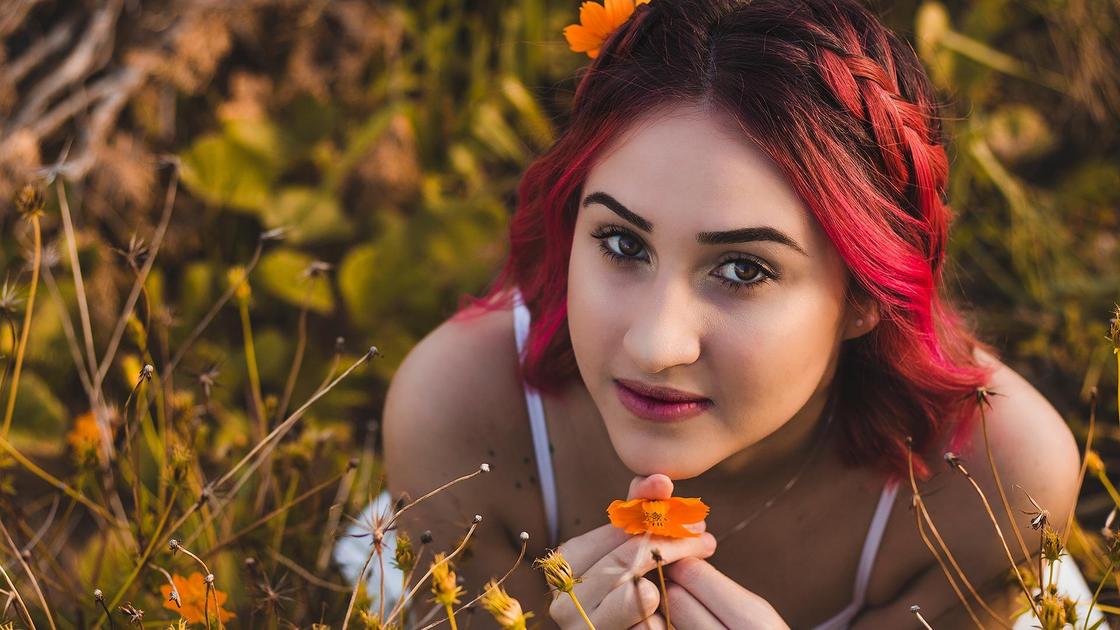 Девушка с красным омбре на волосах в поле