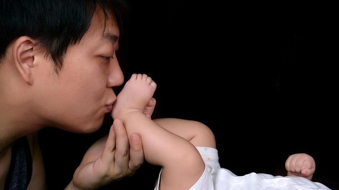 Отец целует ножки малыша