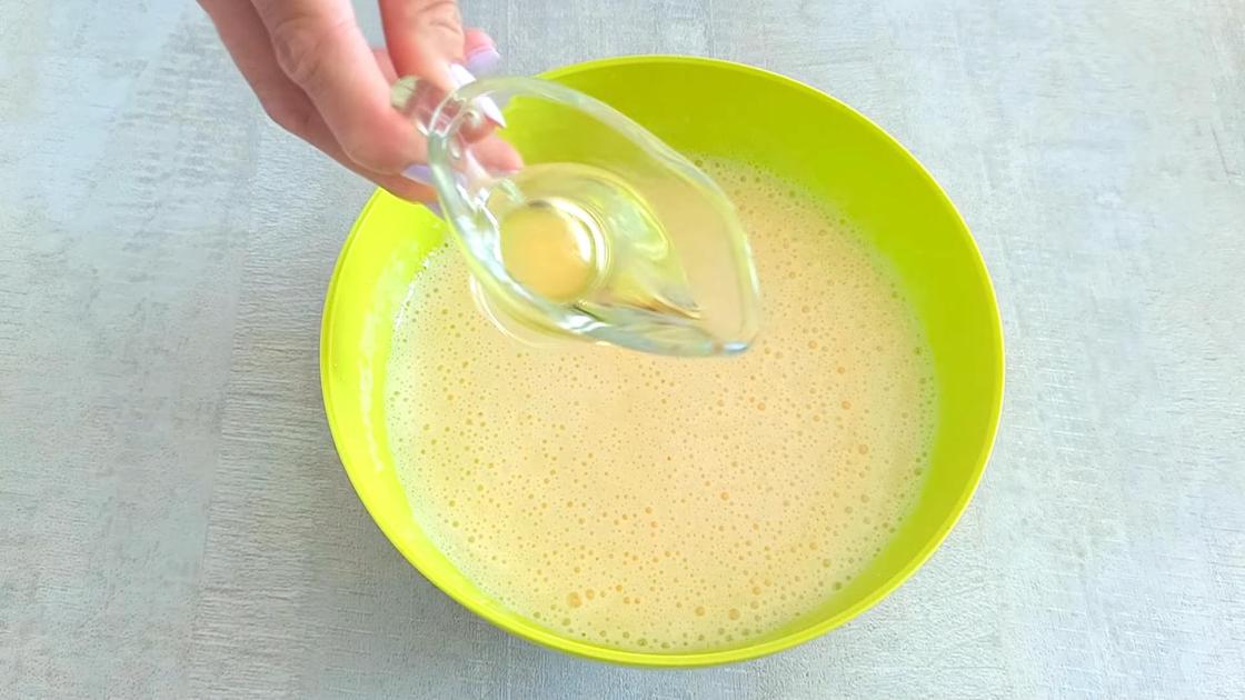 Масло из стеклянного соусника наливают во взбитую кефирно-яичную смесь