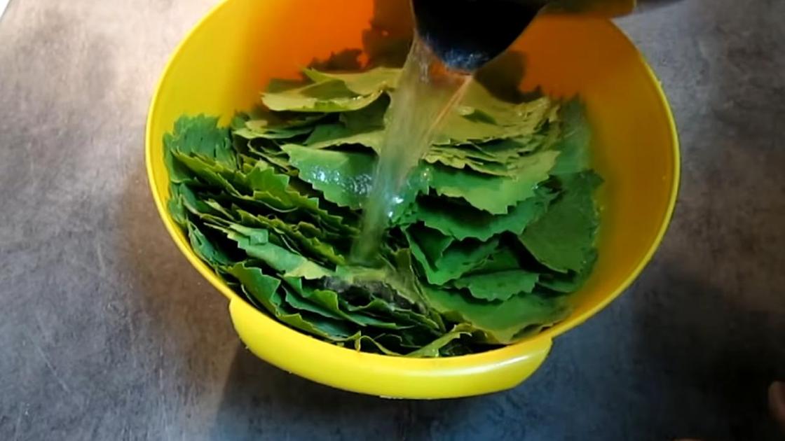Виноградные листья в пластиковой емкости заливают кипятком