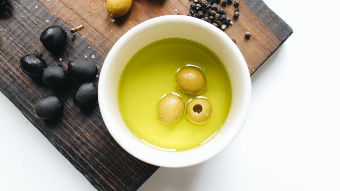 Оливковое масло и оливки в чашке