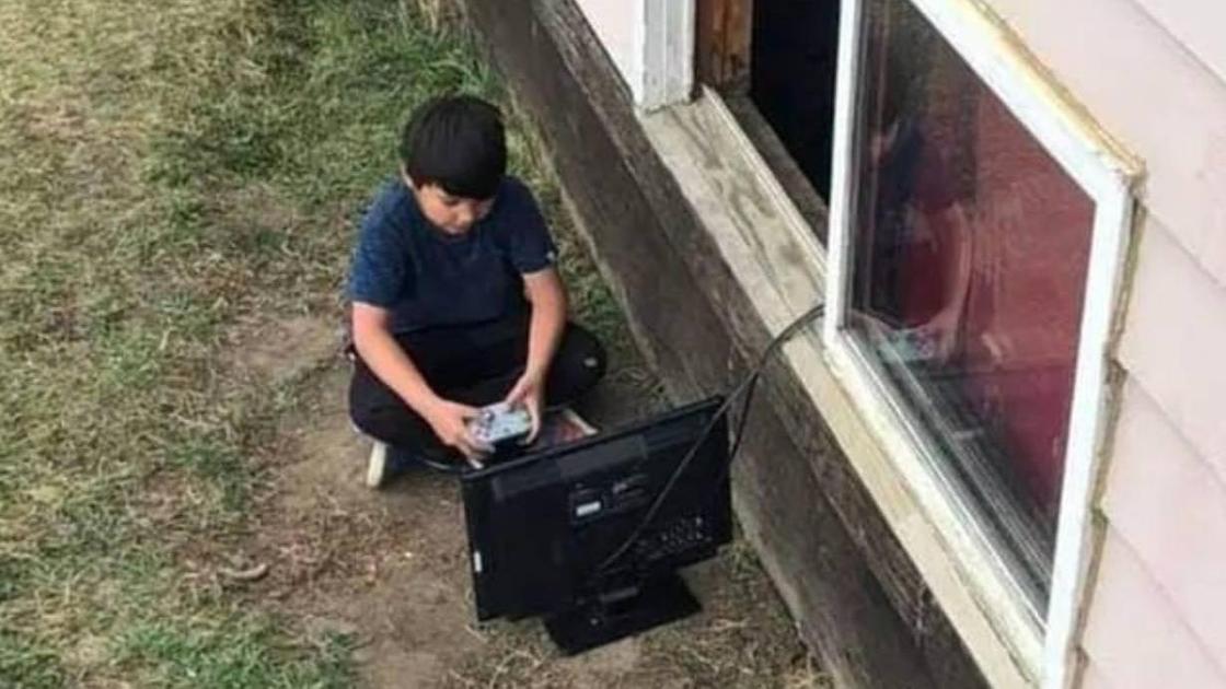 ребенок играет в компьютер на улице