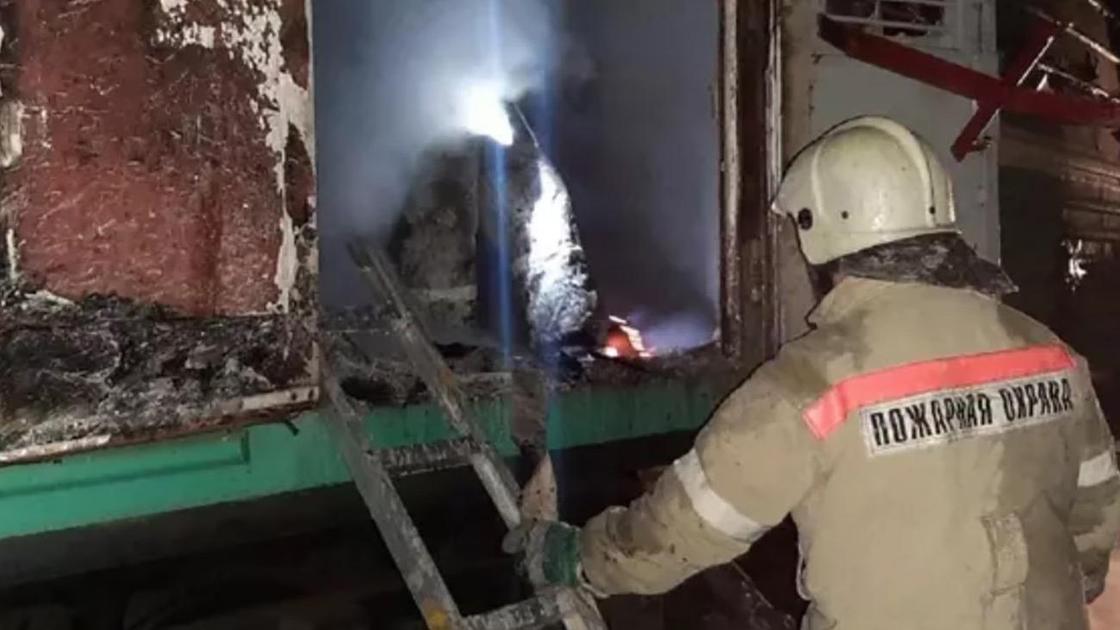 Сотрудник пожарной охраны у сгоревшего вагона поезда