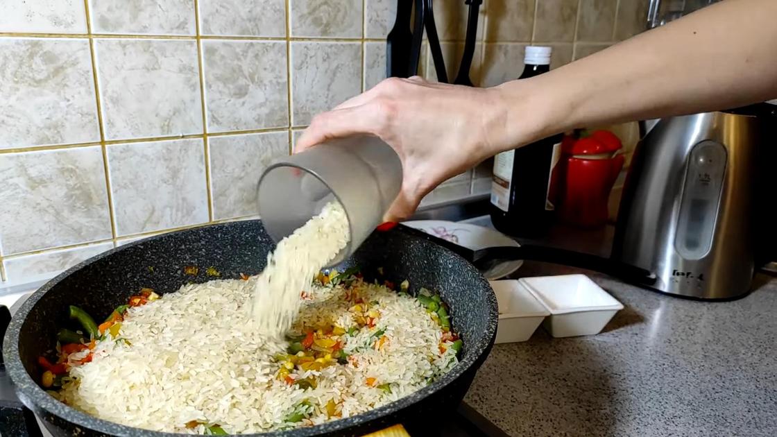 Рис из стакана насыпают в сковороду с овощами