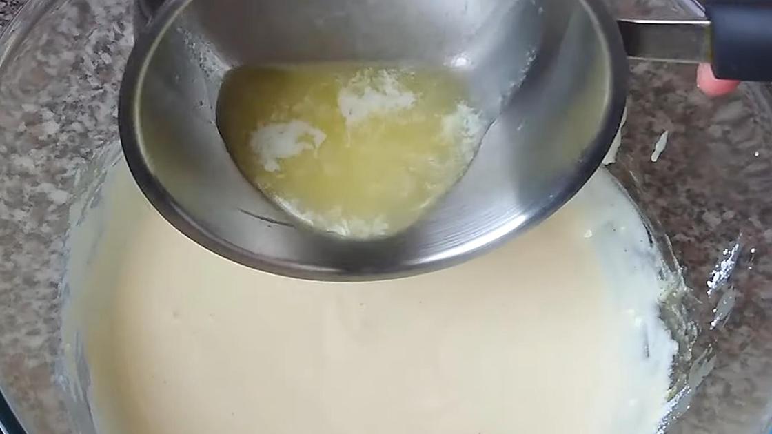 Топленое сливочное масло из сотейника наливают в тесто