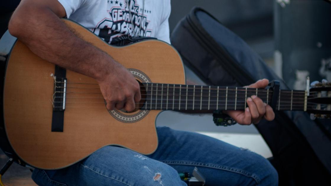 Уличный музыкант играет на гитаре