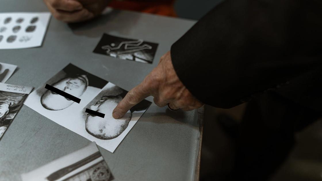Фотографии подозреваемого лежат на столе Фотографии подозреваемого лежат на столе