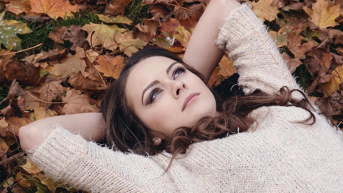 Девушка лежит на осенних листьях