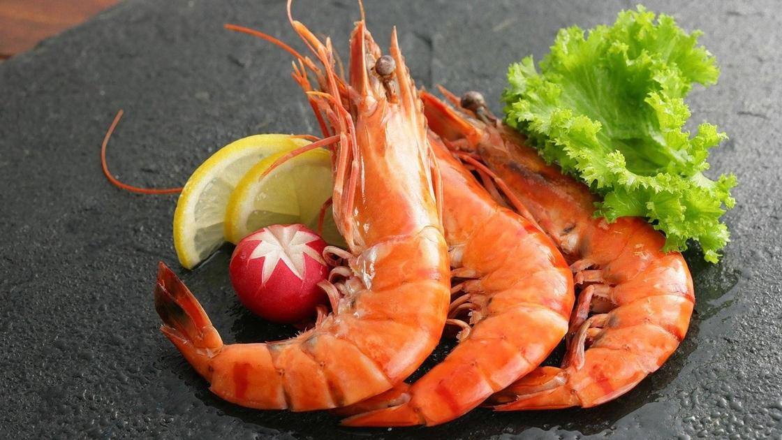Вареные креветки, редис, кусочек лимона, лист салата