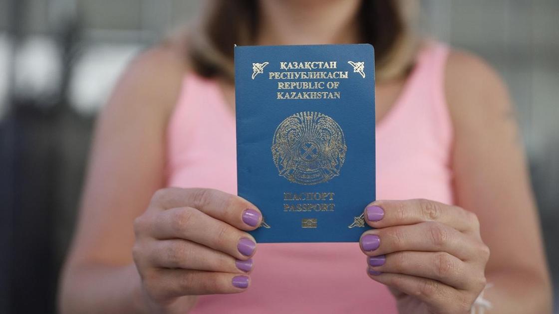 Девушка держит в руках казахстанский паспорт