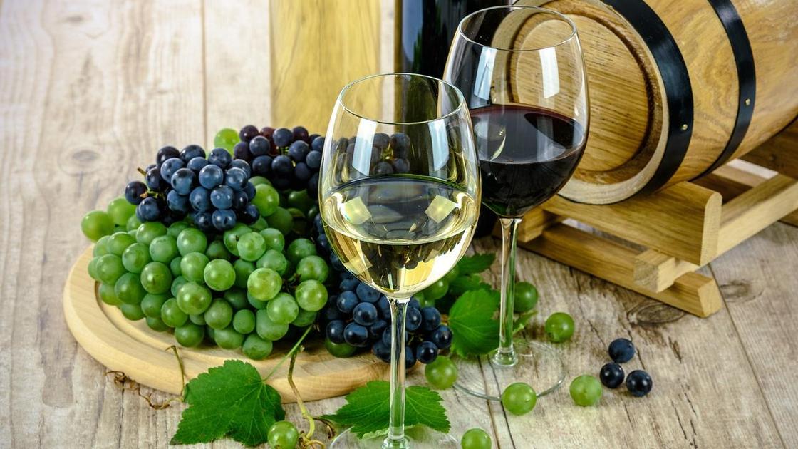 Вино в бокале рядом с виноградом