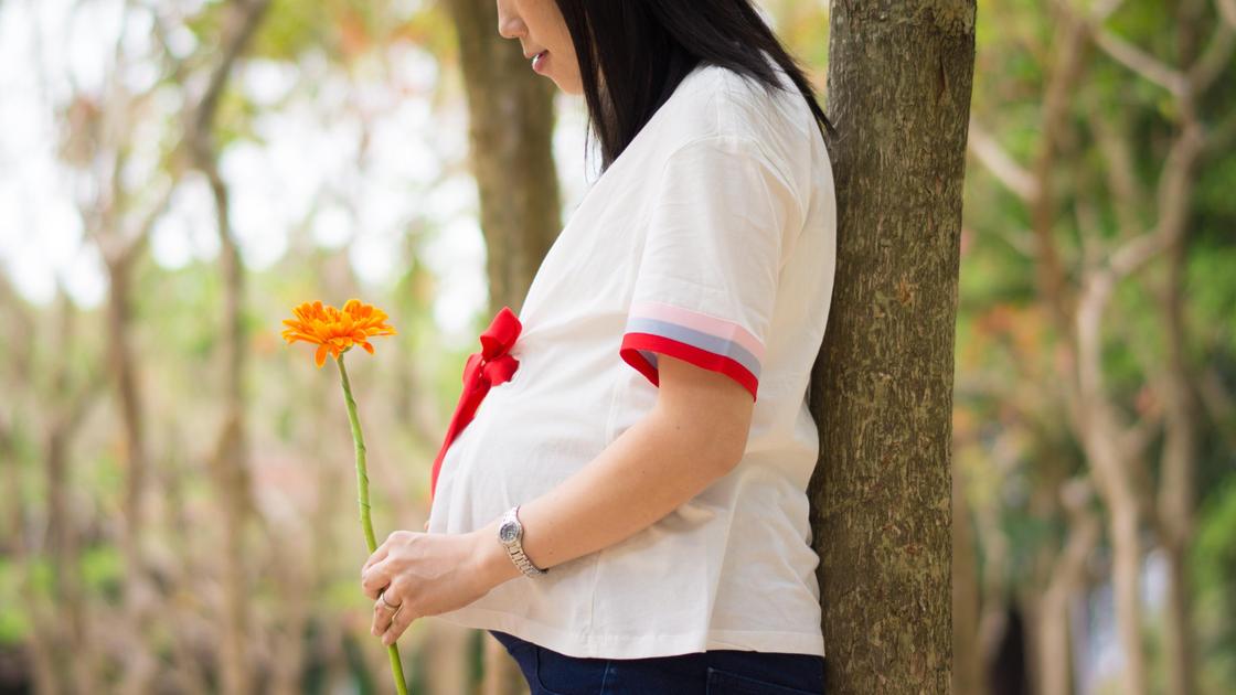 Беременная женщина в белой футболке