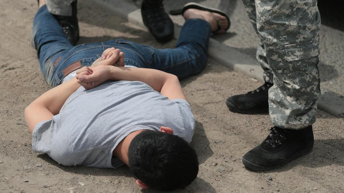 сотрудники правоохранительных органов проводят задержание мужчины