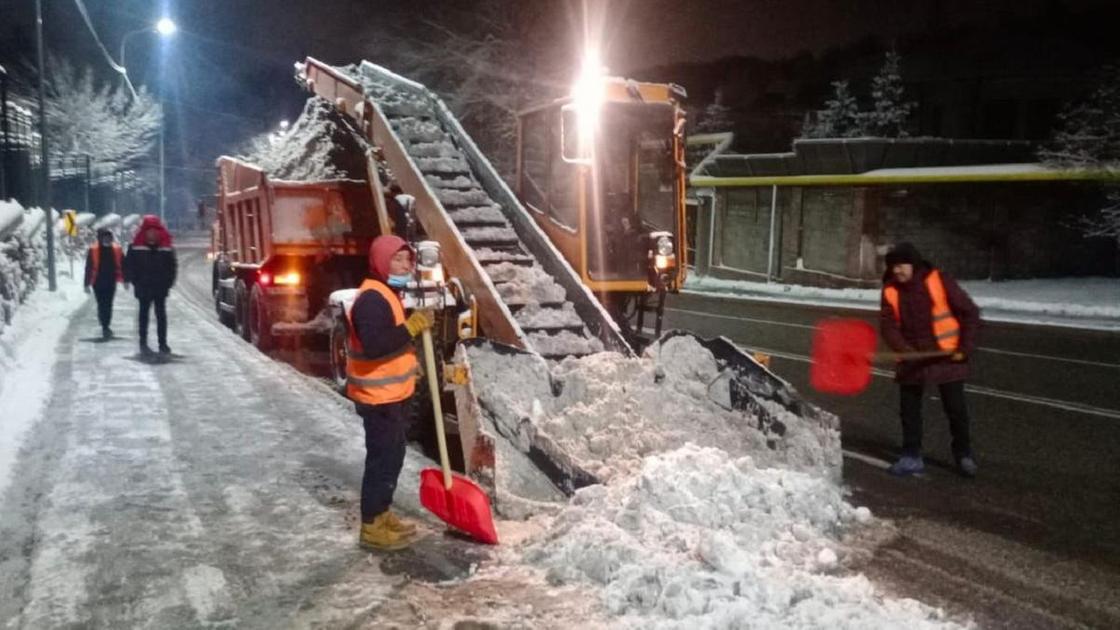 Рабочие убирают снег с улиц Алматы