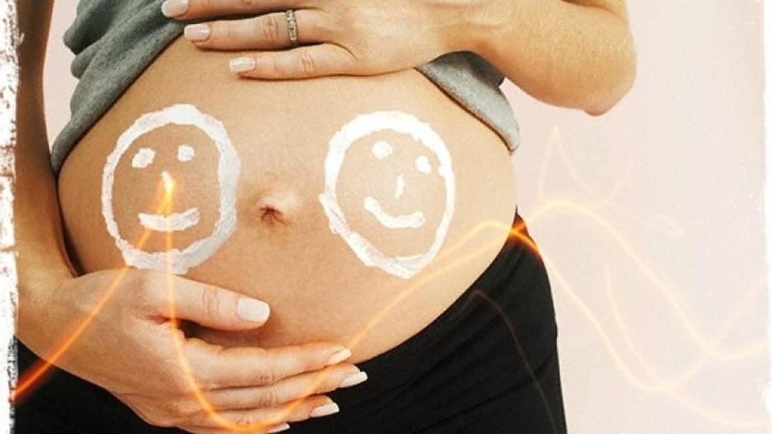 беременная женщина со смайликами на животе