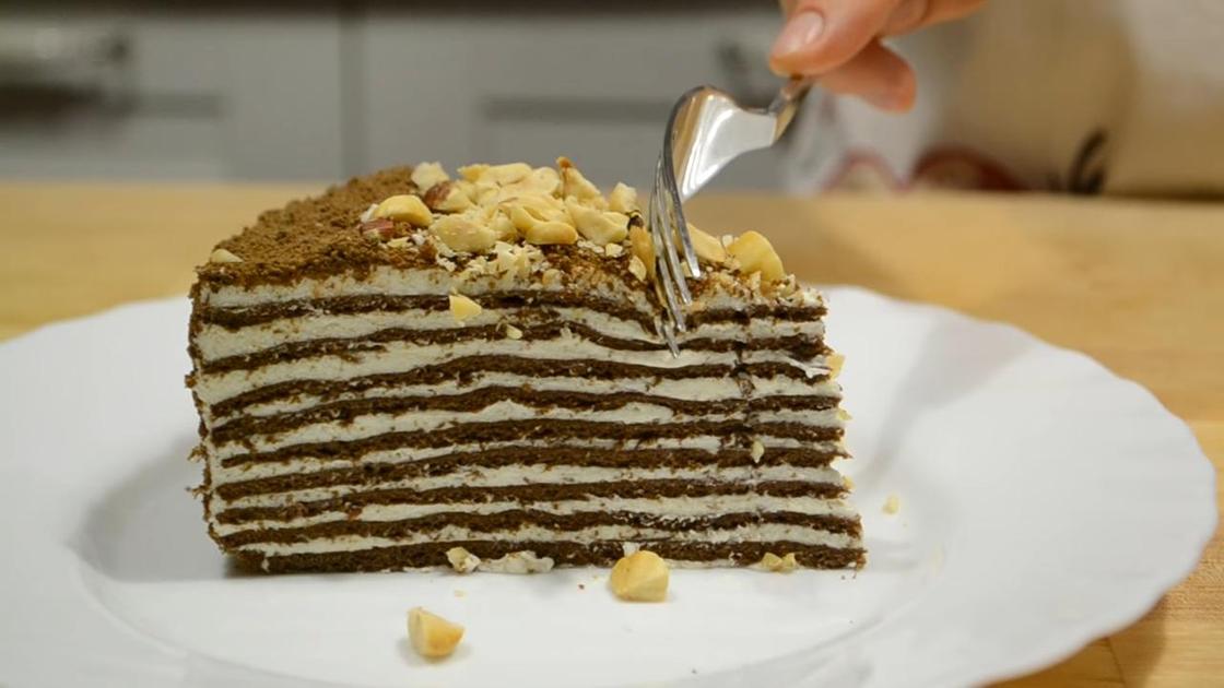 Кусочек торта «Спартак» на сервировочной тарелке с шоколадным декором