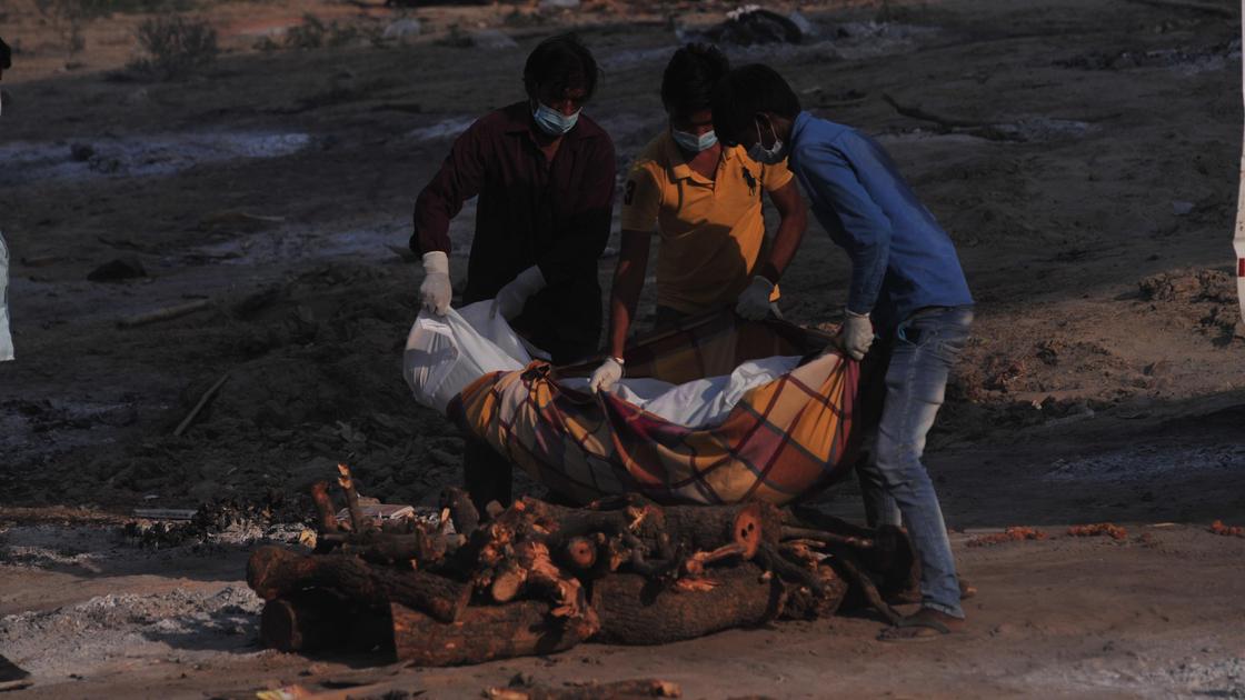Люди кремируют труп в Индии