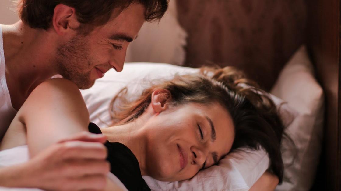 Muž a žena s úsměvem, když ležel v posteli