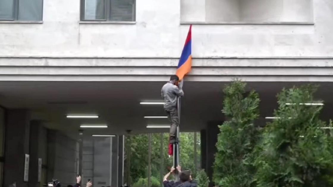 Протестующий устанавливает флаг Нагорного Карабаха