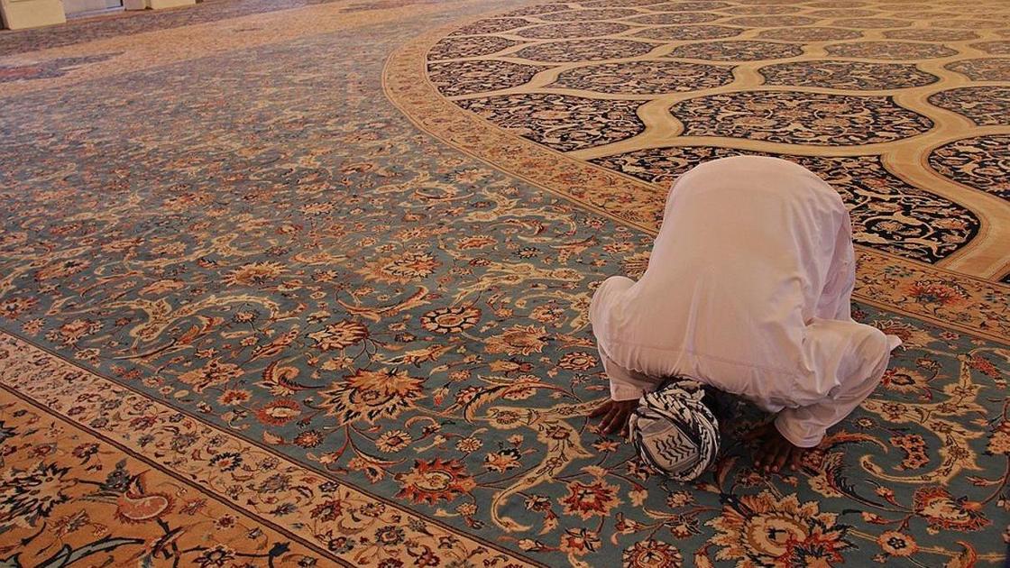 мужчина молится в мечети