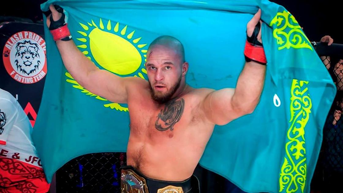 Артем Резников держит флаг Казахстана