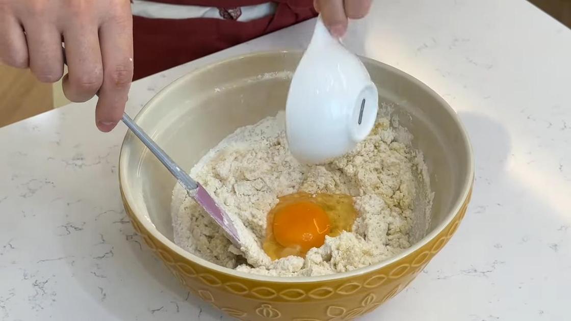 В миску с тестом добавляют яйцо