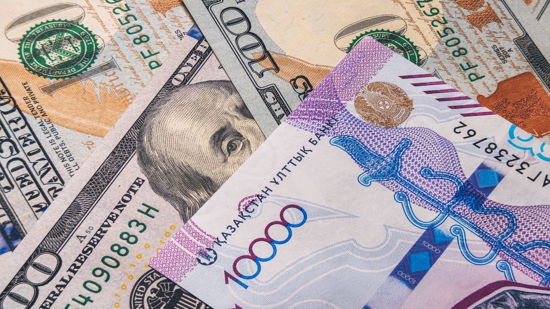 Купюра тенге лежит на долларах