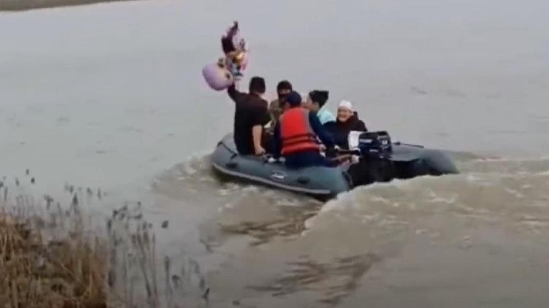 Люди плывут на лодке в Атырауской области