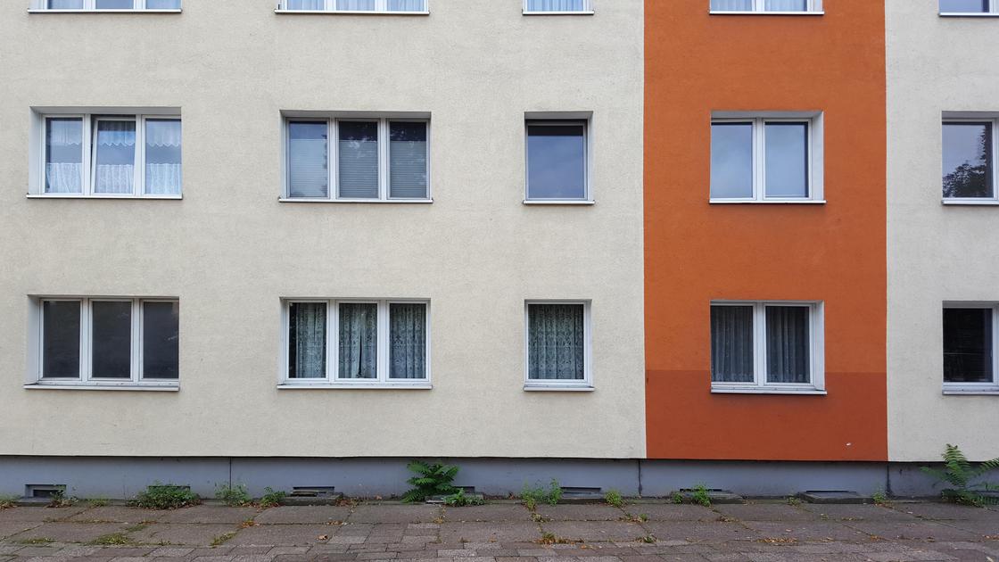 Многоэтажный жилой дом с бело-оранжевыми стенами