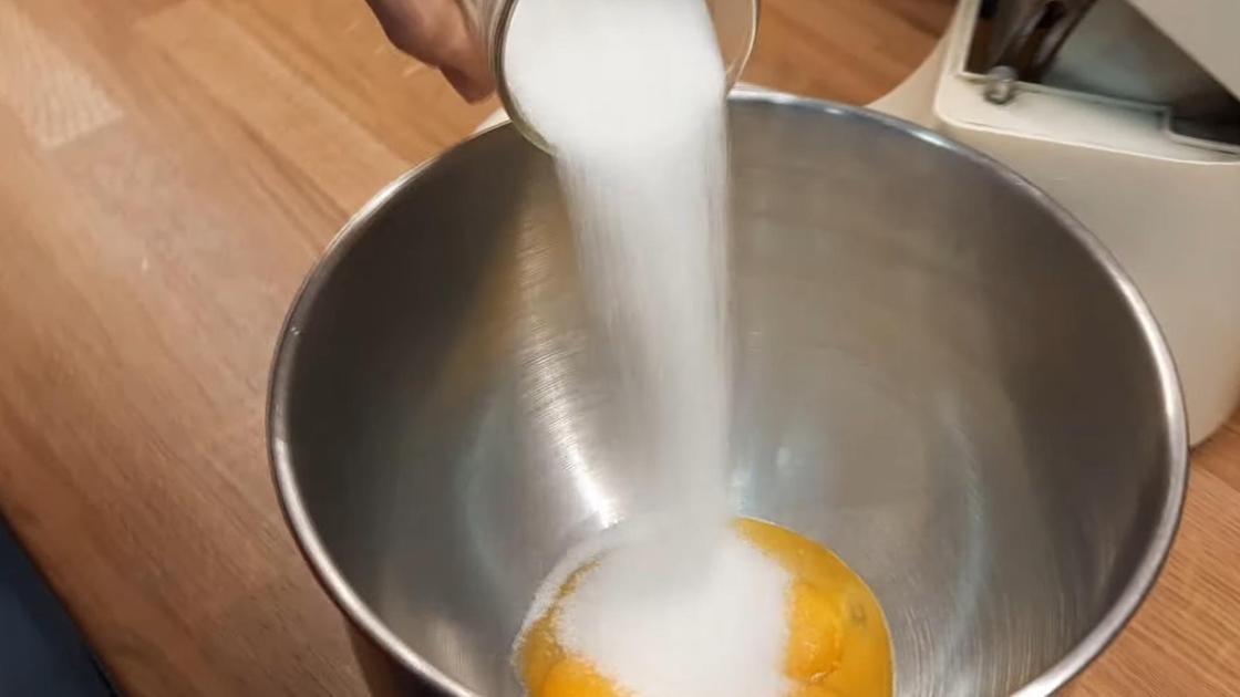 В миску с желтками насыпают сахар