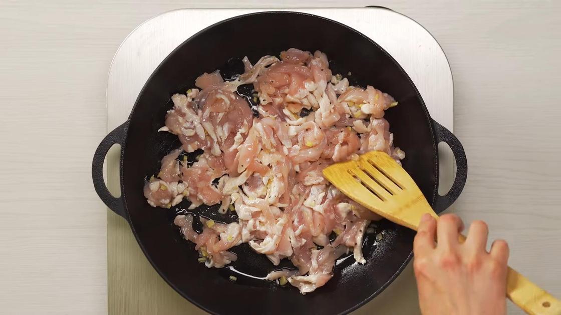 Куриное филе перемешивают на сковороде лопаткой